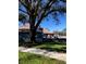 Quaint one-story home with a well-manicured lawn, beautiful tree, and a neutral color scheme at 4559 Oak Arbor Cir, Orlando, FL 32808