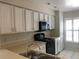 Well-lit kitchen featuring white cabinetry, modern appliances and a tile backsplash at 4559 Oak Arbor Cir, Orlando, FL 32808