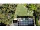 Aerial view of a private backyard with lush greenery and a screened pool enclosure, ideal for relaxation and entertaining at 4901 Shoreline Cir, Sanford, FL 32771