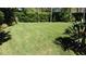 Expansive green lawn bordered by manicured hedges and tropical plants creates a serene and private backyard space at 4901 Shoreline Cir, Sanford, FL 32771