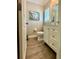 Compact bathroom featuring a toilet, vanity with white cabinets, and decorative beach themed art at 4901 Shoreline Cir, Sanford, FL 32771