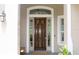 Elegant wooden front door with glass sidelights and transom, complemented by a welcoming porch light at 4901 Shoreline Cir, Sanford, FL 32771