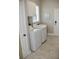 Functional laundry room with a modern washer and dryer, cabinets, and natural light from the window at 4901 Shoreline Cir, Sanford, FL 32771