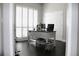 Bright office features a desk with dual monitors, plantation shutters, and wood flooring at 4901 Shoreline Cir, Sanford, FL 32771