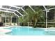 Inviting screened pool area with palm trees, lounge chairs, and ample space for outdoor relaxation and entertaining at 4901 Shoreline Cir, Sanford, FL 32771