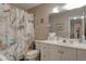Cozy bathroom features a vanity with storage and a framed mirror with decorative shower curtain at 5875 Talavera St, Orlando, FL 32807