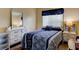 A cozy bedroom featuring a comfortable bed, dresser, and natural light from the window at 5875 Talavera St, Orlando, FL 32807
