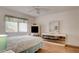 A serene bedroom featuring natural light, a ceiling fan, and a mirrored dresser at 5875 Talavera St, Orlando, FL 32807
