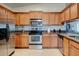 Well-equipped kitchen featuring stainless steel appliances, granite countertops, and wooden cabinetry at 5875 Talavera St, Orlando, FL 32807