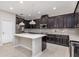 Modern kitchen boasts dark cabinetry, a large island, and stainless steel appliances at 8650 Lovett Ave, Orlando, FL 32832