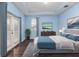 Main bedroom with light blue walls, hardwood floors and access to a balcony at 8650 Lovett Ave, Orlando, FL 32832