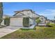 Traditional home features a two-car garage, neat landscaping, and a light blue front door at 1663 Meadowgold Ct, Winter Park, FL 32792