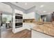 Modern kitchen with double ovens, granite countertops, and white cabinets at 250 Shady Oaks Cir, Lake Mary, FL 32746