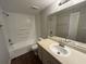 Bathroom featuring a shower-tub combo and a vanity with a large mirror at 4642 Commander Dr # 933, Orlando, FL 32822