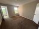 Neutral bedroom with tan carpet, with natural light from a window and a view to another room at 4642 Commander Dr # 933, Orlando, FL 32822