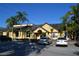 Charming yellow clubhouse, complemented by palm trees, providing a welcoming atmosphere for residents at 4642 Commander Dr # 933, Orlando, FL 32822
