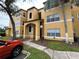 A view of the home's tan exterior with an arched entryway and colorful plants adding curb appeal at 4642 Commander Dr # 933, Orlando, FL 32822