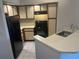 A kitchen featuring matching black appliances, neutral countertops and wood-trimmed cabinets at 4642 Commander Dr # 933, Orlando, FL 32822