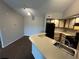 A kitchen featuring matching black appliances, neutral countertops and wood-trimmed cabinets at 4642 Commander Dr # 933, Orlando, FL 32822