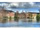 Scenic pond surrounded by lush trees and community buildings, offering a tranquil retreat at 4642 Commander Dr # 933, Orlando, FL 32822
