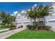 Two-story townhome with gray exterior, two-car garage, and landscaped yard at 15223 Windmill Harbor Ct, Orlando, FL 32828