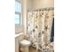 Bathroom with a seashell-themed shower curtain and wood-look tile floor at 3201 Songbird Cir, Harmony, FL 34773