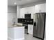 Modern kitchen with white cabinets and stainless steel appliances at 1148 Bancroft St, Deltona, FL 32725