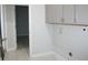 Laundry room with gray cabinets and tile flooring at 1148 Bancroft St, Deltona, FL 32725