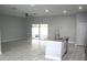 Open living room with tile floors and sliding doors to patio at 1148 Bancroft St, Deltona, FL 32725