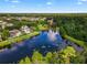 Aerial shot over serene lake featuring nearby homes with pools amid lush greenery at 1401 Celebration Ave # 402, Celebration, FL 34747