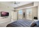 Main bedroom featuring a ceiling fan, TV, and natural lighting from exterior door and windows at 1401 Celebration Ave # 402, Celebration, FL 34747