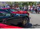 Black Ferrari in a row of other Ferraris during a car show outdoors, crowded by other people at 1401 Celebration Ave # 402, Celebration, FL 34747