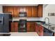 Kitchen boasts dark wood cabinets, granite countertops, and black appliances at 1401 Celebration Ave # 402, Celebration, FL 34747