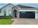 Charming single-story home with stone-accented entryway, manicured lawn, and brick driveway at 2475 Hastings Blvd, Clermont, FL 34711