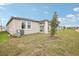 Backyard with green lawn, patio, and young tree, perfect for enjoying outdoor space at 507 Kennedy Dr, Lake Alfred, FL 33850