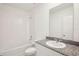 A bright bathroom with a shower/tub combo and a vanity with a granite countertop at 507 Kennedy Dr, Lake Alfred, FL 33850