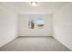 This bedroom features neutral carpet, white walls, a ceiling light, and two windows at 507 Kennedy Dr, Lake Alfred, FL 33850