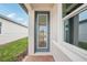 Close-up of a modern glass front door entrance with brick pavers, providing a bright, welcoming view inside at 507 Kennedy Dr, Lake Alfred, FL 33850