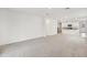 Open-concept living space with neutral carpet that flows into a modern kitchen with white cabinets and appliances at 507 Kennedy Dr, Lake Alfred, FL 33850