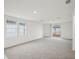 Spacious living room featuring neutral carpet, natural light, and a sliding glass door to the backyard at 507 Kennedy Dr, Lake Alfred, FL 33850