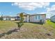 View of backyard featuring grassy lawn, newly built home, and young trees at 510 Kennedy Dr, Lake Alfred, FL 33850