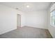 Neutral bedroom featuring gray carpet, white walls, a window, and a closet door at 510 Kennedy Dr, Lake Alfred, FL 33850