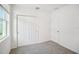 A bright bedroom features a window, gray carpet, and a double door closet at 510 Kennedy Dr, Lake Alfred, FL 33850