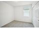 Neutral bedroom featuring gray carpet, white walls, a window, and a closet door at 510 Kennedy Dr, Lake Alfred, FL 33850