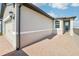 A home exterior is seen with a brick paver driveway leading up to an attached garage and covered entry at 510 Kennedy Dr, Lake Alfred, FL 33850