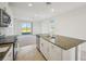 Bright, open kitchen featuring granite countertops, stainless steel appliances, and a view into the living area at 510 Kennedy Dr, Lake Alfred, FL 33850