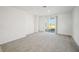 Bright and airy living room featuring modern gray carpet and sliding glass doors to the outdoor space at 510 Kennedy Dr, Lake Alfred, FL 33850