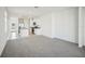 Bright, open-concept living room featuring modern gray carpet, stainless steel appliances, and neutral walls at 510 Kennedy Dr, Lake Alfred, FL 33850