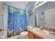 Cheerful bathroom features a blue shower curtain with whimsical fish decor and a vanity sink at 16608 Rising Star Dr, Clermont, FL 34714