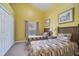 Cozy bedroom with two twin beds, yellow walls, and bright natural light from the window at 16608 Rising Star Dr, Clermont, FL 34714